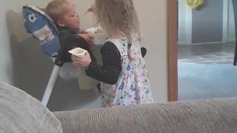 Little lady feeding her baby brother