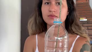 Woman Practices Magic Trick with an Apple and a Bottle