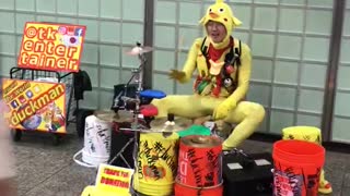 Man in yellow body suite playing drums