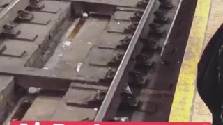 Worker trying to pick up white headphones from train track with claw