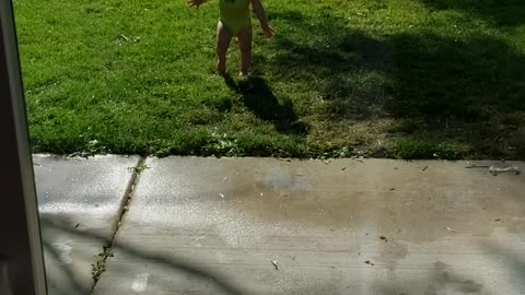 1 year old excited in sprinklers