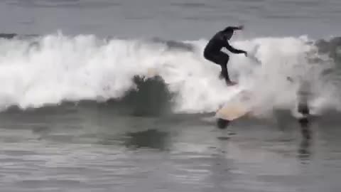 Black wetsuit two surfers collide surf