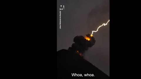 lightning bolt strikes volcano while it's erupting