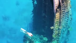 In the clear waters surrounding Keioda, Maldives, lies a sunken ship half submerged.