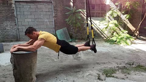 Strong muscular guy workout with trx