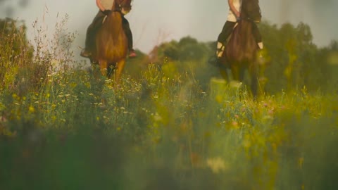 Two girls ride horses on a blurred background