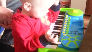 Little boy falls playing toy piano