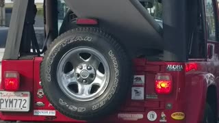 Red jeep car with surf board outside