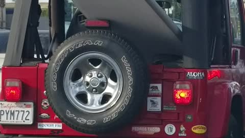 Red jeep car with surf board outside