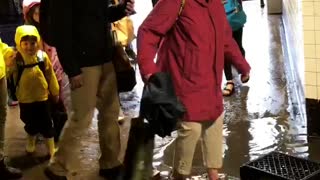 People walking through flooded subway underground tunnel