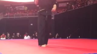 Guy black karate uniform spinning nunchucks backflip fail