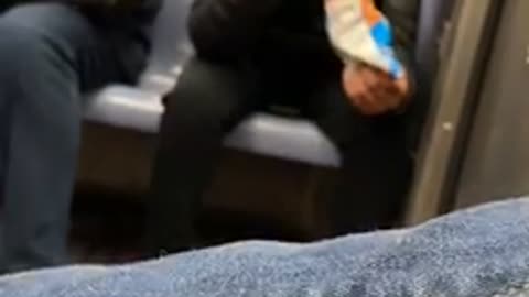 Woman wearing airpods sucks on her cheeto puffs on subway train