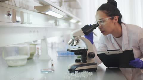 A Female Scientist Writing Data Of Samples Under Study Uploaded at April 10, 2020
