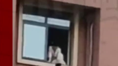 Child plays on high-rise window ledge in China. #Shorts #China #BBCNews