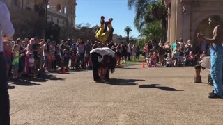 Street performer front flips over 4 people