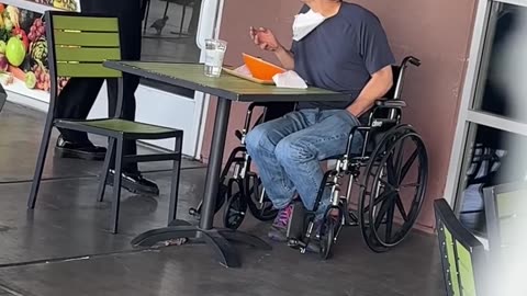 Kind waitress feeds disabled man