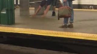 Man in black shirt does yoga stretches in subway station