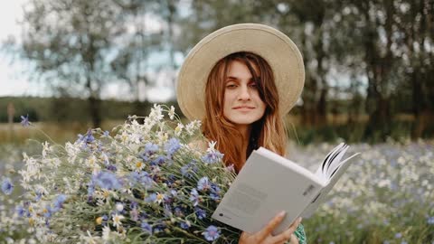 A Woman Reading A Book With Flowers On Hand