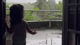 Cute baby loves to see the rain in a beautiful evening