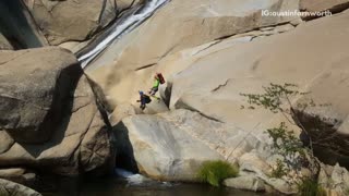 Five guys slide down rock into water
