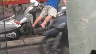 Man Rides Motorcycle in Unusual Way