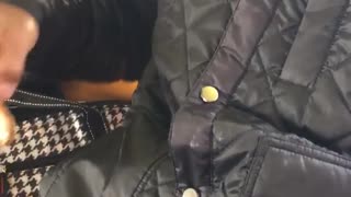 Man takes out chicken nugget from jacket pocket and eats it on subway train