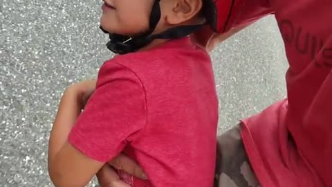 Little boy spiderman helmet skateboard dad down street