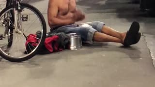 Shirtless guy streets singing drums singing gibberish