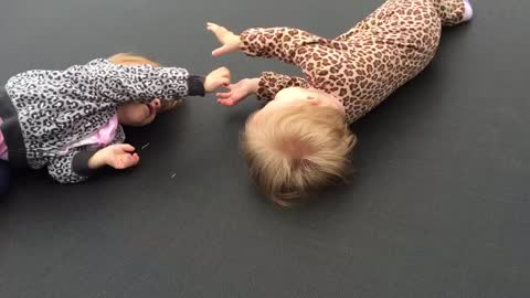 Precious identical twins play together with their hands