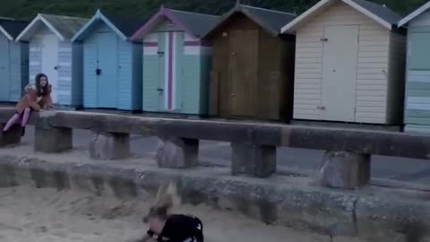 Little Girl Faceplants in Sand After Attempting to Perform Front Flip Off Rail