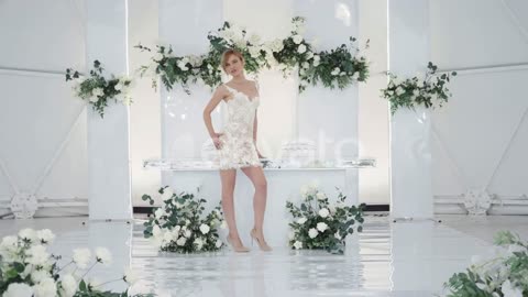A Beautiful Model Wedding in a White Dress on poses Against backdrop of a Beautiful design