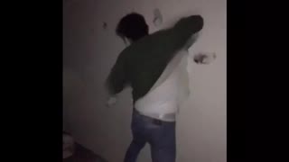 Guy in green shirt hits white wall and makes holes