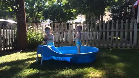 adorable twins having fun in the pool