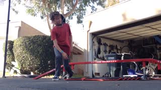 Kid in red shirt skating on ramp falls down