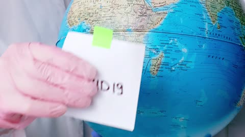 People With Face Masks and Latex Gloves Holding a Globe Uploaded at April 17, 2020