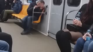 Drunk guy on subway train falls down into his seat and looks dazed