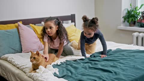 Kids Petting Their Cat On The Bed