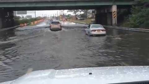 Vehicles drive through flooded underpass in Lindenhurst, NY