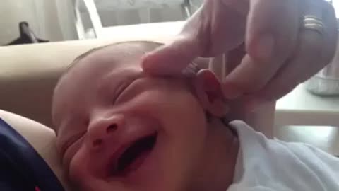 New born baby enjoying mom tickeling his head