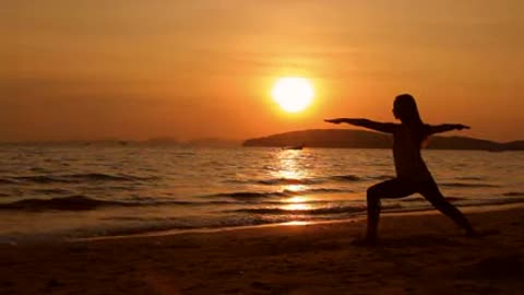 Sunset Beach Yoga A woman performing yoga moves on the beach at sunset.