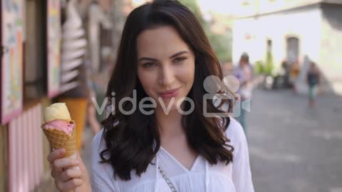 Beautiful brunette woman eating delicious and sweet ice cream