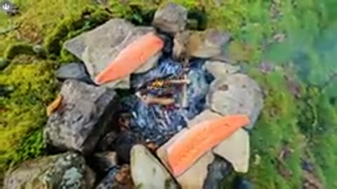 SALMON cooked and smoked over fire