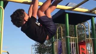 Black shirt kid falls face first off yellow jungle gym