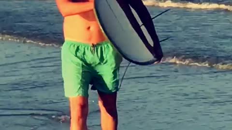 Surfer takes knee on beach