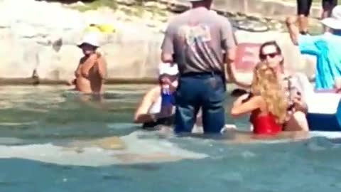 Fully dressed man jeans and white hat in water