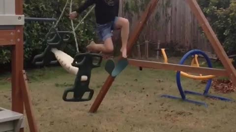 Little girl on green backyard kid swing falls off