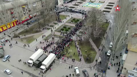 Drone Footage Citizens lined up in a big queue infront of trucks with food in Kherson, Ukraine