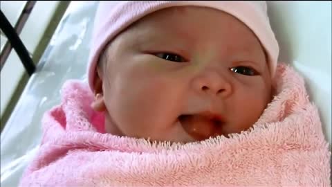 Newborn baby with big eyes and lips as red as lipstick