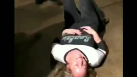 Woman tries to do kickflip on skateboard, jumps and falls down