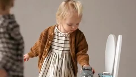 A Girl Arranging her Toys on the Chair